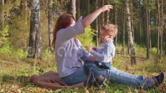 幸福的家庭在草坪上休息妈妈用温柔和爱和孩子玩儿子笑他玩得很开心快乐视频的预览图