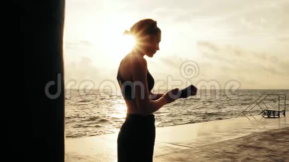 运动的女人用绷带包住站在阳光下准备拳击手套视频的预览图