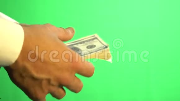 一个穿衬衫的商人手拿着一把Chroma钥匙上面有一百美元钞票视频的预览图