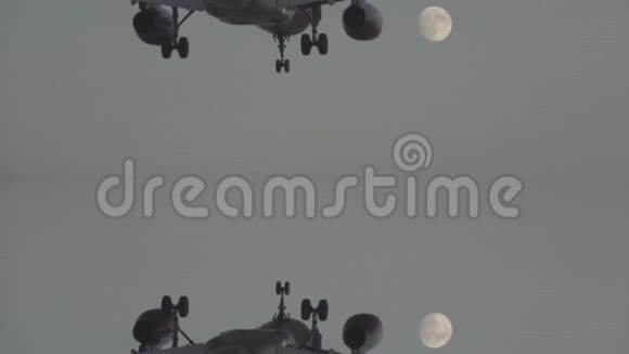 黄昏时分在满月的衬托下喷气式飞机缓慢降落视频的预览图
