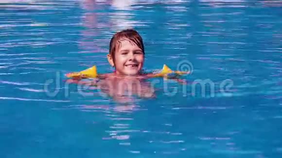 一个小女孩正在游泳池里游泳那孩子正在蓝色的池子里洗澡和溅水视频的预览图