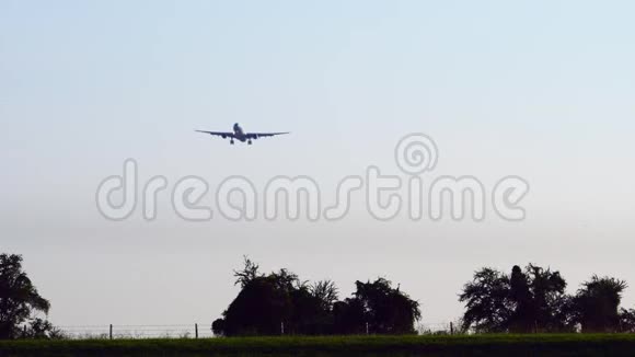 商业航空公司客机降落在机场美丽的日落天空和云彩抵达航班飞机飞行视频的预览图