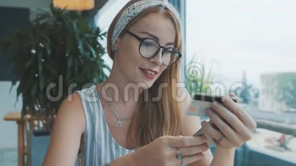 用信用卡和手机买有趣礼物的女人女性在网吧购物视频的预览图