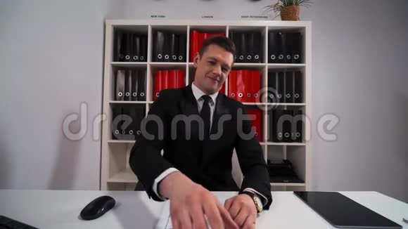 年轻英俊的商人穿着黑色西装打着领带数欧元视频的预览图