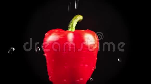 红椒特写水滴落在黑色背景上旋转的苹果上超级慢动作视频的预览图