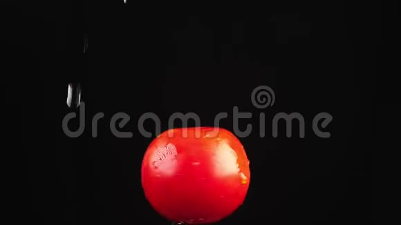 红色番茄特写水滴落在黑色背景上旋转的苹果上超级慢动作视频的预览图