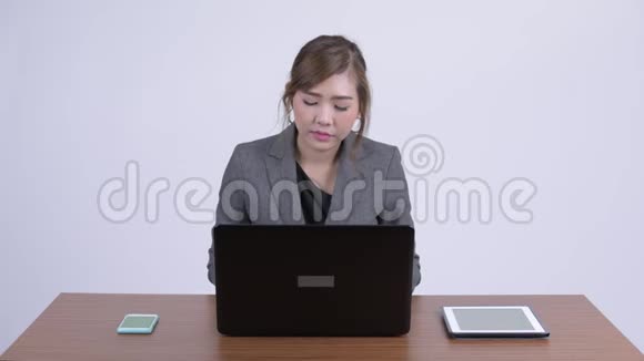 年轻漂亮的亚洲女商人工作时用笔记本电脑视频的预览图