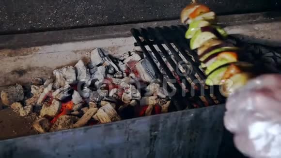 戴手套的人在烤架上放蔬菜肉串视频的预览图
