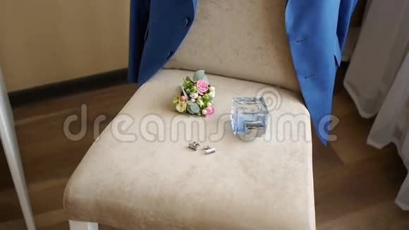 优雅的男士婚礼用品带扣孔的马桶水躺在椅子上他的夹克挂在背面视频的预览图