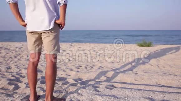 日落时分人们站在沙滩上享受平静的大海视频的预览图