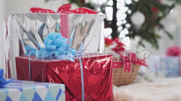 时尚的礼品盒和装饰模糊的杉树和圣诞老人的背景慢动作3840x2160视频的预览图
