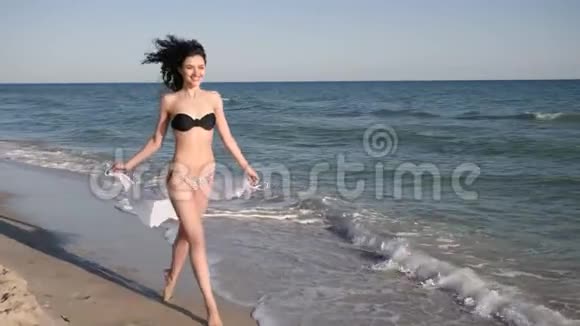 穿着泳衣的快乐女孩在沙滩和大海上奔跑自由快乐的女人在热带旅行视频的预览图