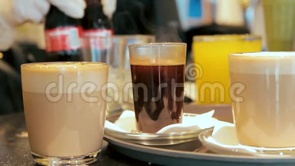 在一家咖啡馆里柜台上摆放着许多装有咖啡和果汁的玻璃杯视频的预览图