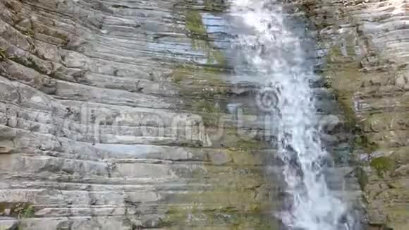 干净的水从旧石头上掉下来石头墙上的瀑布视频的预览图