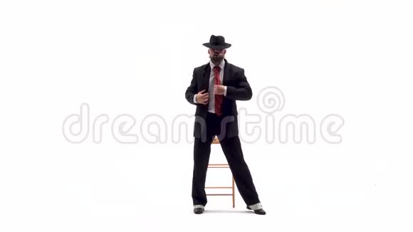 戴着黑帽子的优雅男人正在跳情色舞他用椅子和香烟白色背景视频的预览图