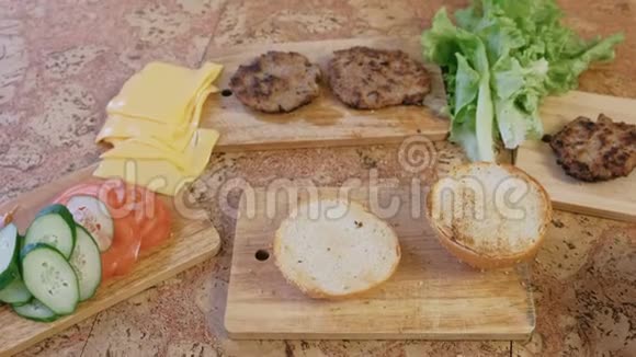 准备汉堡的产品面包西红柿黄瓜小切片奶酪沙拉酱汁桌子上的培根视频的预览图