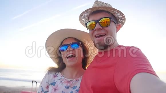 快乐的旅行情侣在海滩上打电话自拍视频的预览图