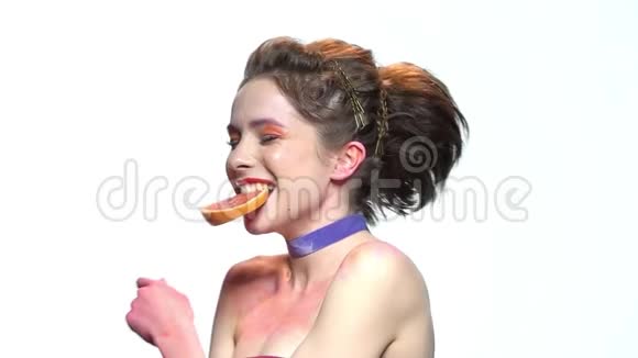 漂亮的女孩咬葡萄柚切片视频的预览图