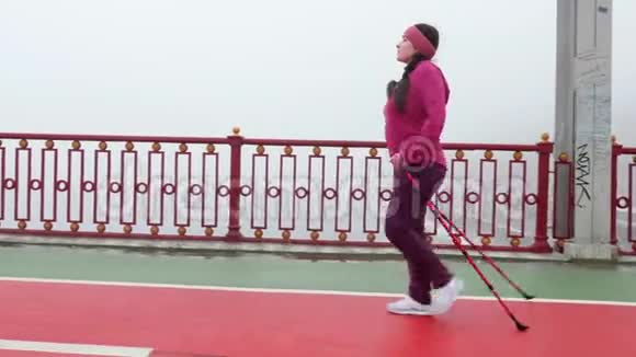 北欧式步行年轻胖乎乎的白人女人和北欧两极徒步旅行侧面跟随射击视频的预览图