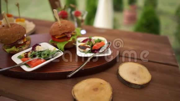 盘子上的汉堡包和色拉自然地陈列在一张木桌上视频的预览图