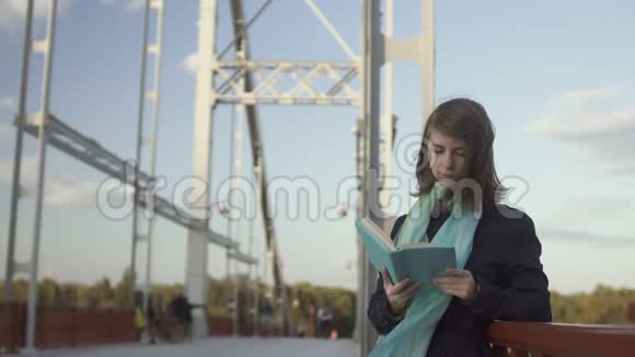漂亮的小女孩在桥上看书视频的预览图