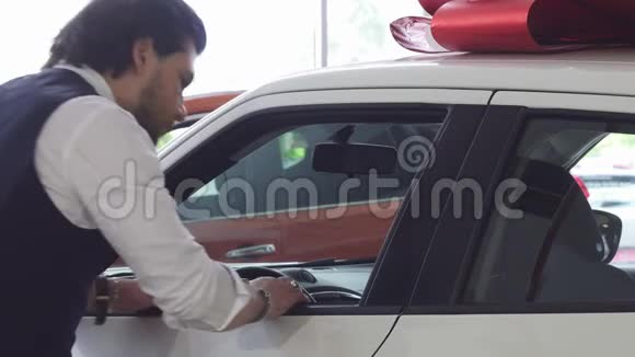 帅哥在检查一辆新车时对着镜头微笑视频的预览图