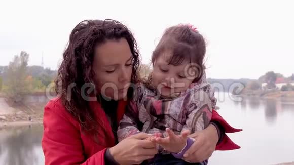 妈妈和女儿在河岸上玩一个小女孩和她妈妈在河边一起玩视频的预览图