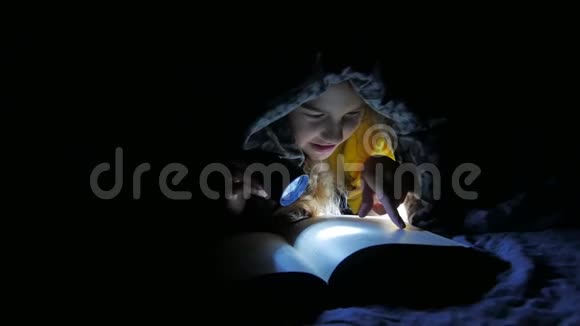 小孩和爱看狗的女孩晚上用儿童手电筒在毯子下看书视频的预览图