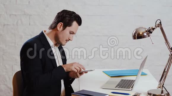 年轻的商人在电脑前工作打电话视频的预览图