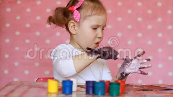 有趣的孩子用油漆画他的手小艺术家小女孩画画视频的预览图