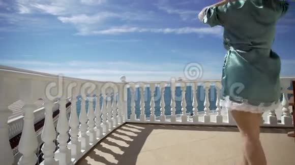 穿浴袍的年轻女子来到阳台视频的预览图