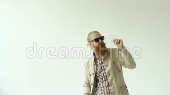 戴墨镜的年轻滑稽胡子男在白色背景下跳舞视频的预览图
