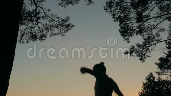 日落后年轻快乐的女人在森林里跳跃跳舞玩得开心视频的预览图