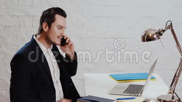 年轻的商人在电脑前工作打电话视频的预览图
