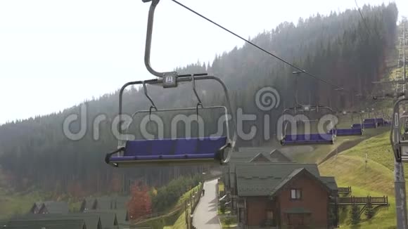 在一个阳光明媚的秋天在山上的滑雪胜地Bukovel的滑雪升降机的低角度拍摄蓝天太阳和森林视频的预览图