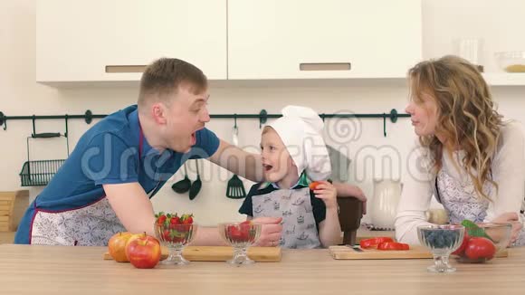 一家人正在厨房准备沙拉儿子给爸爸妈妈喂草莓视频的预览图