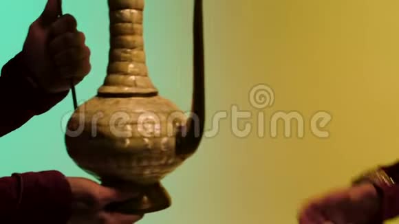 男士双手赠送东方陶瓷壶蓝黄背景古色古香的商品销售理念库存程序视频的预览图
