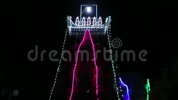 夜间五颜六色的装饰照明外部拍摄印度南印度传统寺庙视频的预览图