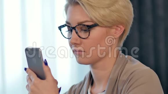迷人的快乐女性正在休息时通过手机阅读男友发来的愉快短信视频的预览图