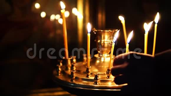 一个人在东正教的图标前纠正燃烧的蜡烛视频的预览图