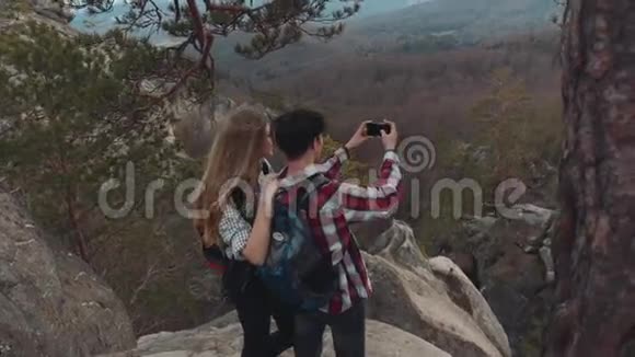 年轻的欧洲黑发男子和金发女孩一起在山顶上度过了一段美好的时光拍摄了视频的预览图