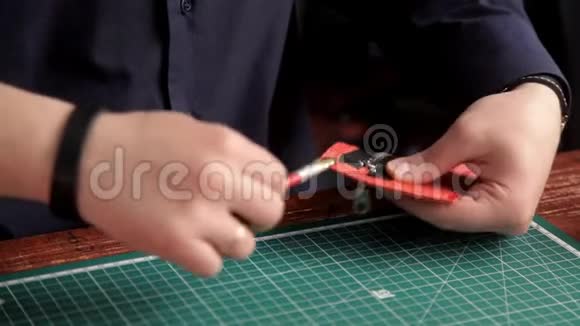 在车间里一个男人用胶水粘在皮肤的工件上做了一个钱包视频的预览图