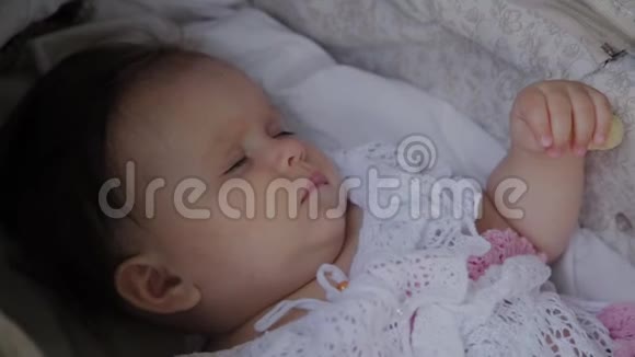 漂亮的小女孩睡在街上的婴儿马车里视频的预览图