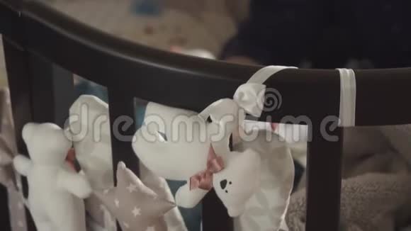 年轻的母亲用一瓶牛奶喂她的小儿子孩子在摇篮里睡着了妈妈关心视频的预览图