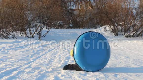 在晴朗的冬日女孩在雪管里玩耍躲在雪管后面视频的预览图