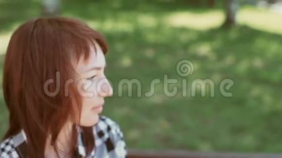 一个在公园长椅上荡秋千的女孩视频的预览图