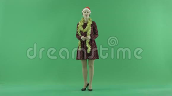 一位年轻的圣诞女士在绿色的屏幕上展示着幸福视频的预览图