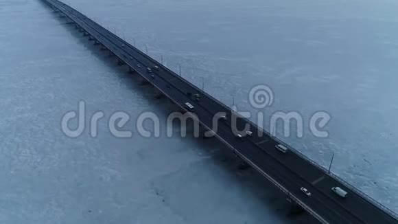 一条结冰的白河上的桥上交通的空中镜头视频的预览图