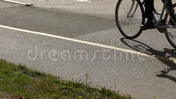 骑自行车的影子在沥青上缓慢移动视频的预览图