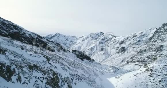 后向俯视冬季雪山岩峰落基山脉的山顶覆盖着冰雪冰川视频的预览图